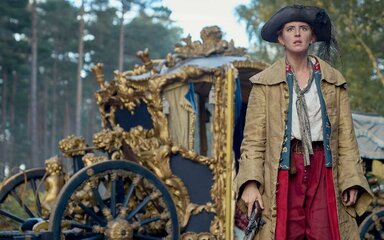 18th century robber in front of golden coach in a forest